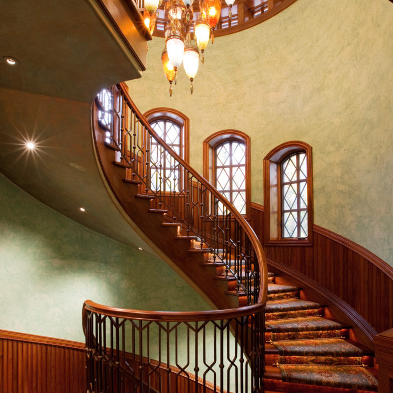 Traditional Curved Staircase in Black Walnut with Iron Panels