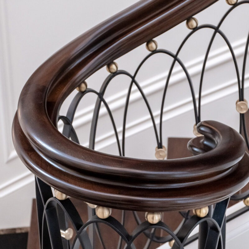 Custom Classic Curved Staircase with Forged Iron and Mahogany Rail